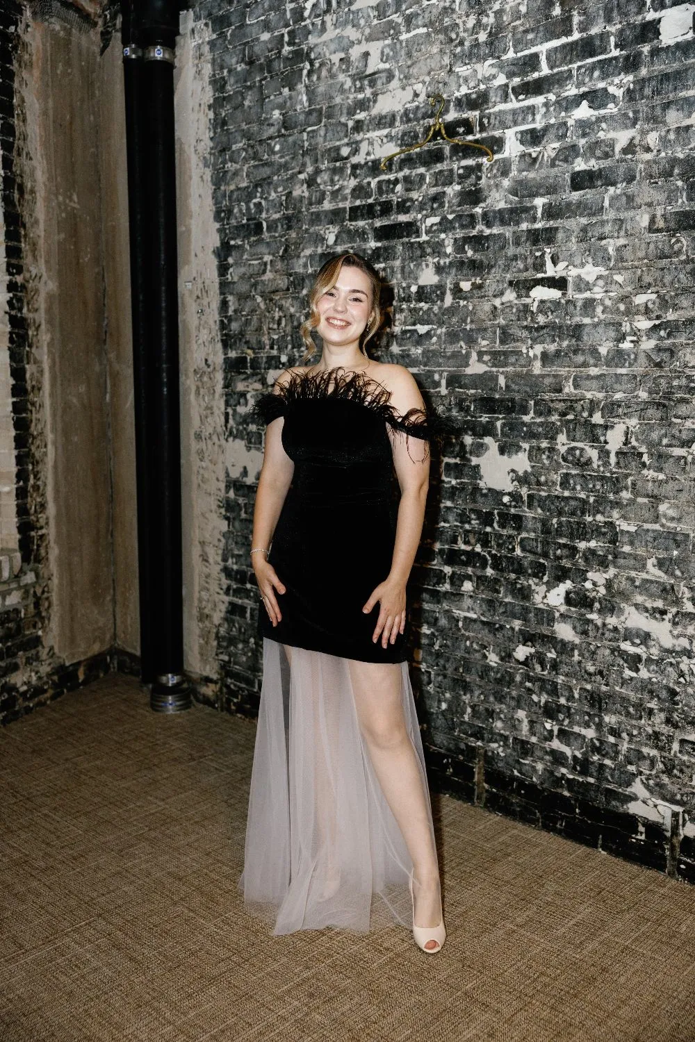 Aleksandra Safonova in a black velvet gown with blush tulle and ostrich feathers at the shoulder