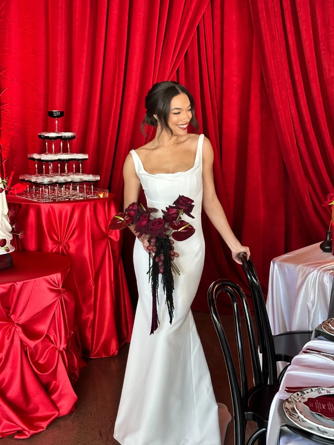 Deep red draped column gown with a long train, photographed on set in Oregon