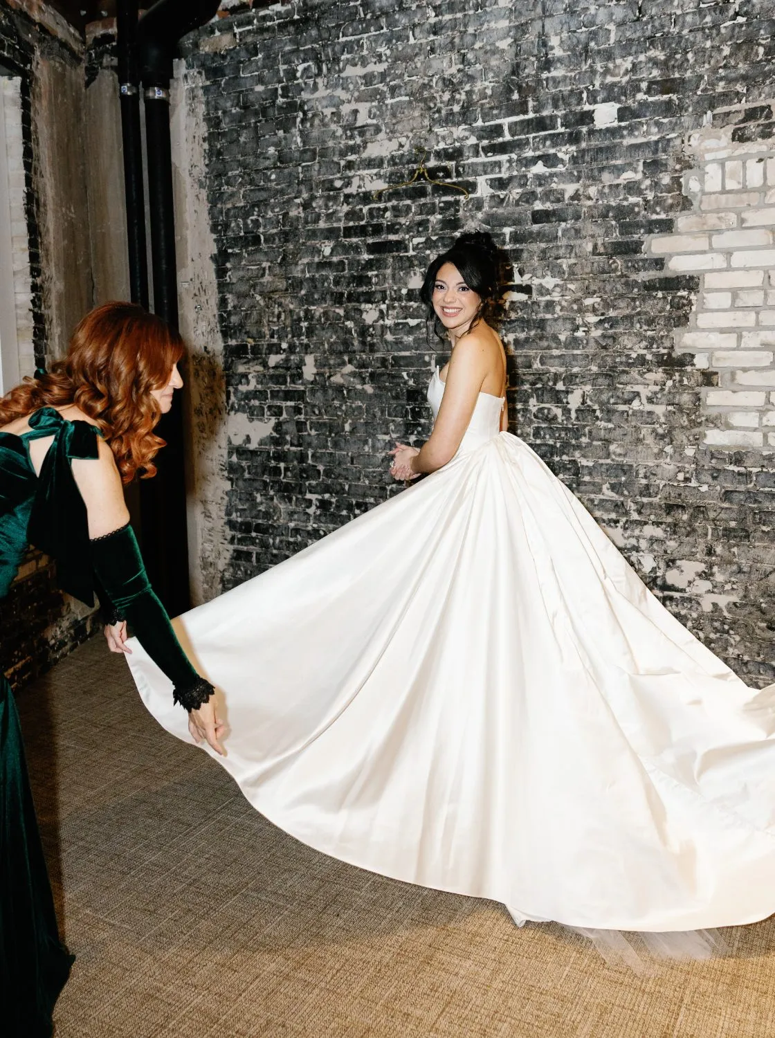 The bride turning, the silk train spread across the floor