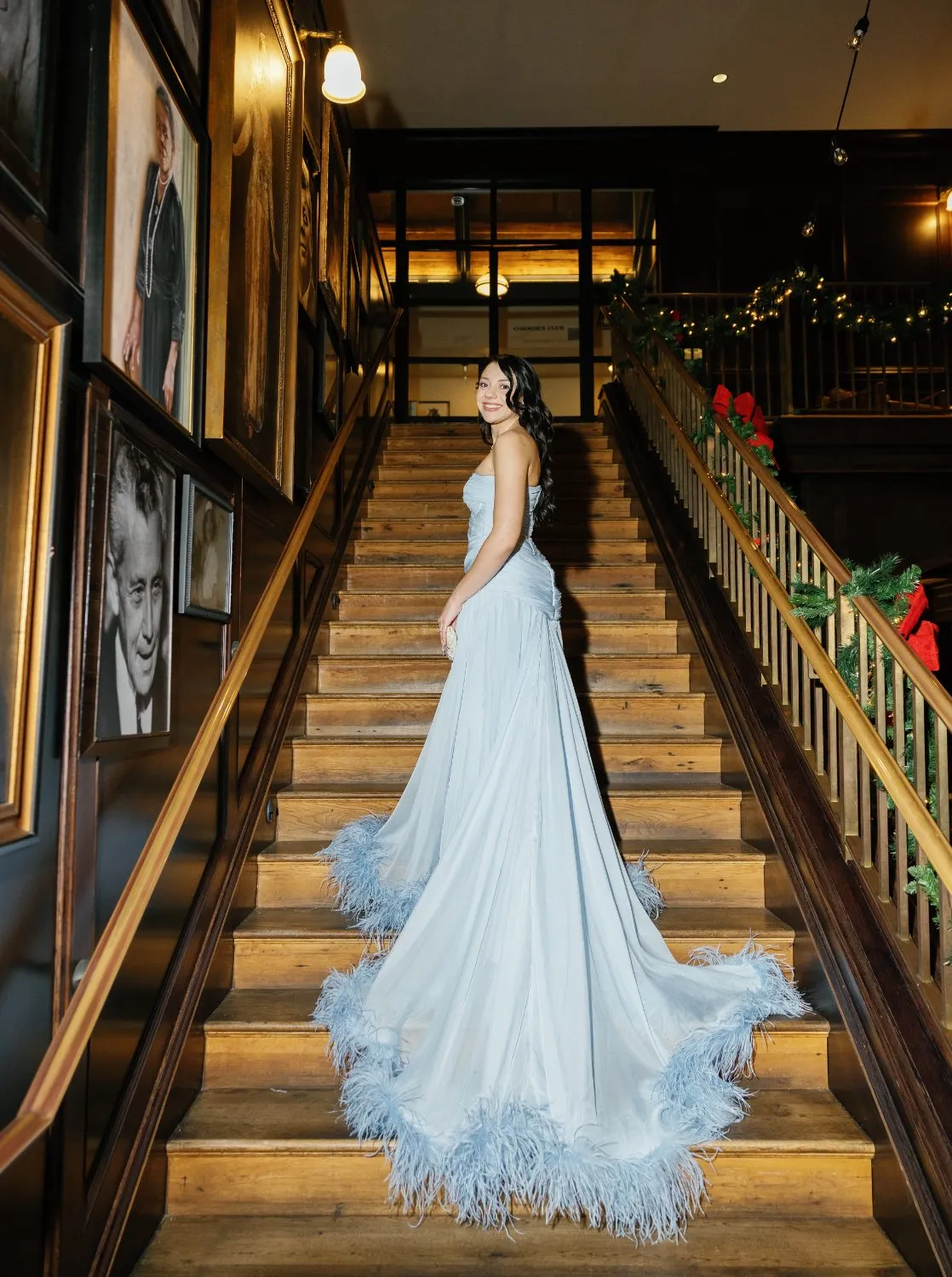 Blue feathered evening gown on the Oxford Exchange staircase